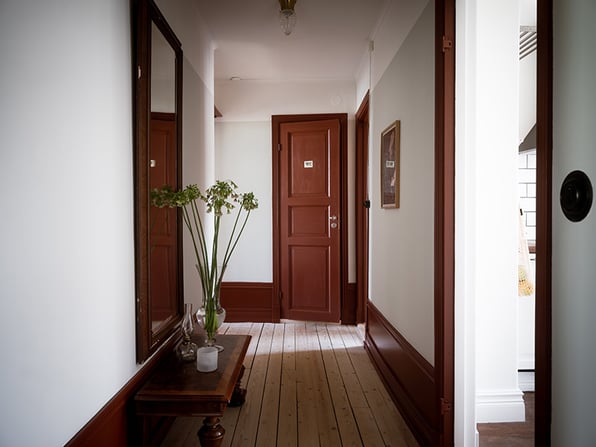 hall med mörkt målade dörrar och snickerier