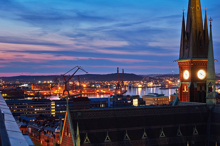Bostadsrätt – fin utsikt över kyrka och hamninlopp i skymningen i Göteborg  