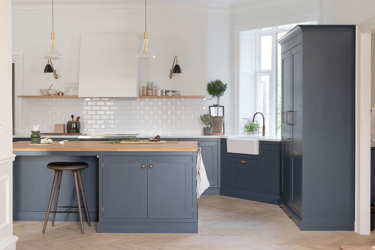 Köksinspiration: Köket Dalby, handmålat i kulören Hav. Bänkskivor i vit Silestone och på köksön ek. Handtag och knoppar i brons och diskho i porslin.