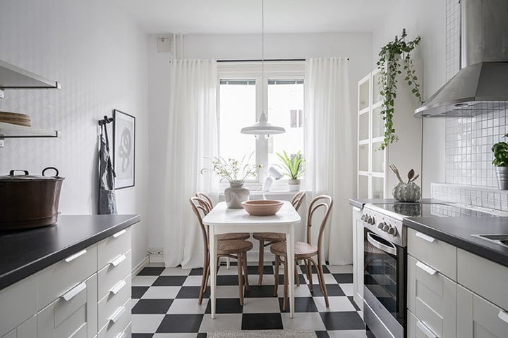 Köpa eller sälja först - kök med schackrutigt golv och vita köksskåp i en bostadsrätt
