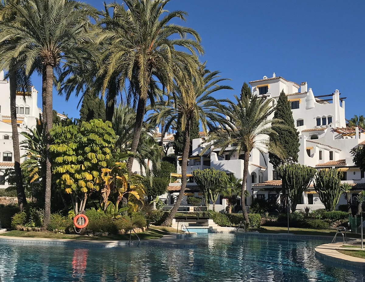 Aldea Blanca, Marbella, Solkusten. En pool, palmer och vackra bostäder. 