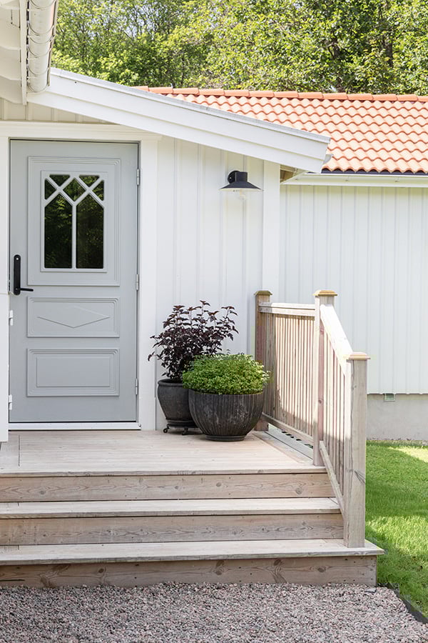trätrappa som leder upp till grå dörr