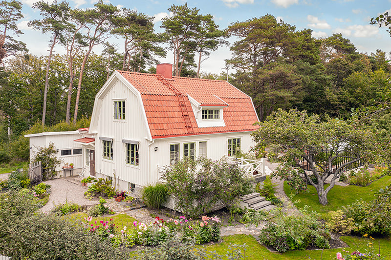 vit trävilla med blomstrande trädgård